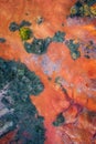 Gant, Hungary - Aerial horizontal drone view of abandoned bauxite mine with warm red and orange colors and tree at sunset