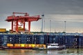 Gantry Crane Loading Container onto Truck with Tug and Barge in Foreground