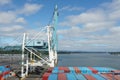 Gantry cranes ready for cargo operation parked behind merchant ship moored in container terminal in Portland