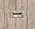 Gap in the fence designed to receive letters. The wooden fence is painted in a Sepia color.