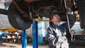 Garage automobile service - a mechanic checks the suspension Royalty Free Stock Photo