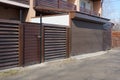 Garage with brown iron gates and a wooden fence Royalty Free Stock Photo