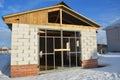 Garage door construction frame.A car brick garage under construction with unfinished roof, brick walls, and metal garage door