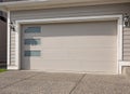Garage door in luxury house. A perfect neighbourhood. Family house with wide garage door and concrete driveway in front Royalty Free Stock Photo
