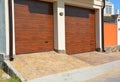 Garage door for two cars with pathway pavement and plastic gutter pipes.