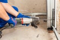 Garage doors installation. Worker drills a hole for the bolt.