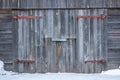 Garage facade with old gray wooden gates. Old garage door