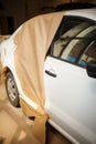 Garage painting car service. vehicle cover with protective paper before painting.