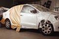 Garage painting car service. vehicle cover with protective paper before painting.