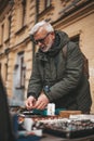 Garage sale, mature man buys antiques at the flea market. Elderly collector