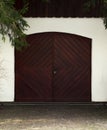 Garage wooden gate with a metal handle on the background of a white plastered wall Royalty Free Stock Photo