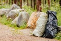 Garbage bags for cleaning forest from plastic and biological debris. Environmental pollution concept