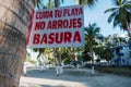 Garbage on the beach. Warning sign