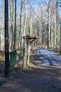 garbage bin and information board near walking path