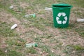 Garbage bin next to plastic trash on a ground background. Bright container for rubbish recycling. Environment, ecology Royalty Free Stock Photo