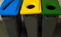 Garbage bins with colour coded lids for recycling and sorting different materials .