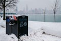 Garbage can at Chicago shoreline overflowing with Dunkin donuts bags facing the Chicago skyline Royalty Free Stock Photo