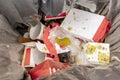 Garbage can with the remains of disposable food packaging and disposable glasses of soft drinks Royalty Free Stock Photo