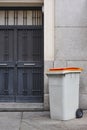 Garbage can on an urban building entrance door. Green environment Royalty Free Stock Photo