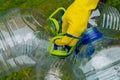 Hand in yellow glove holding big empty plastic bottles. Grass on a background Royalty Free Stock Photo