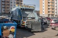 Garbage collection service, A waste collector working on emptying garbage cans for garbage collection with waste loading on a truc