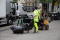 Garbage collection worker putting bin into waste truck. For removal