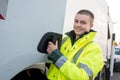 garbage collector smiling next to truck