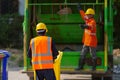 Garbage collector, teamwork garbage men working together on emptying dustbins for trash removal with truck loading waste and trash