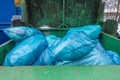 a garbage compactor there are many blue garbage bags to be pressed together Royalty Free Stock Photo