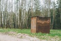 Garbage container in countryside, in birch grove. Brown rusty trash can on the grass in forest Royalty Free Stock Photo