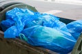 Garbage container filled with blue bags