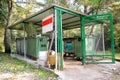 Garbage containers in fence cage / Orderly stowed garbage cans for separate garbage collection.