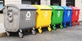 Garbage containers with separated garbage on a street. Trash bins for plastic, glass, paper and organic. Segregate waste and