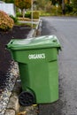 Garbage day, large plastic green yard waste bin sitting out at the curb, recycling of organics and yard waste Royalty Free Stock Photo