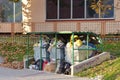 View of overflowing carbage containers on a street side walk with trash plastic bags littered around