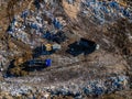 Garbage dump and working dump truck and bulldozer, aerial top view