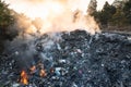 Garbage and fire burn in landfill cause of air pollution, environmental damage and global warming. Royalty Free Stock Photo