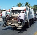 Garbage men behind the garbage truck