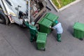 Garbage men loading household rubbish in garbage truck, top view