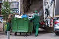 Garbage men operating garbage truck, solid household waste collection