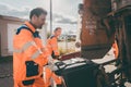 Garbage man and women cleaning dustbins into waste truck