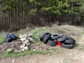 garbage and old car tires are lying in the forest