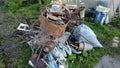 Garbage pile with iron and plastic on the grass. Heap with old rusty iron, tanks, containers, springs.