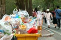 Garbage plastic Waste trash full of trash bin yellow and background people are walking on the sidewalk garden, Garbage bin, Trash Royalty Free Stock Photo