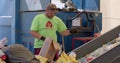 Garbage recycling worker unpacks plastic waste. Sorts paper and plastic.