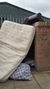 Collection of fly tipping articles against brick and metal fencing