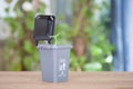 In the garbage sorting, the gray trash can model containing other garbage opens the lid and sprouts grow out