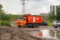 A garbage truck with an inscription in Russian on its body - Recycling Company, drives around a puddle in a residential Royalty Free Stock Photo