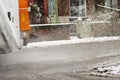 Garbage truck rides on big puddle in snowy day. Sleet splash on Royalty Free Stock Photo