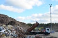 Garbage truck unloads construction waste from container at the landfill. Industrial waste treatment processing plant. Recycling